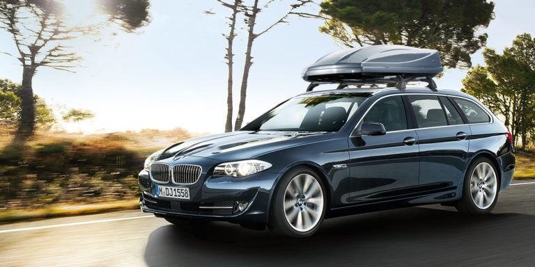 Beispielbild für Dachboxverleih. Ein fahrender BMW mit Dachbox auf dem Autodach.