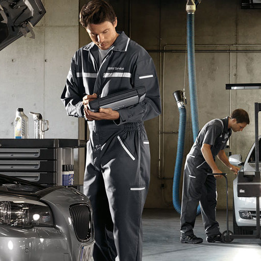Beispielbild für HU / AU bei einem BMW. Mechaniker kontrolliert Funktionstüchtigkeit des Fahrzeugs.