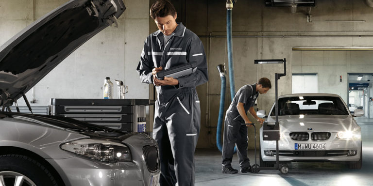 Beispielbild für HU / AU bei einem BMW. Mechaniker kontrolliert Funktionstüchtigkeit des Fahrzeugs.