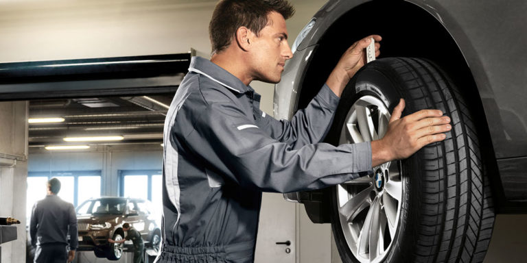 Mechatroniker wechselt Reifen eines Fahrzeugs. Beispielbild für Räder- und Reifenservice.