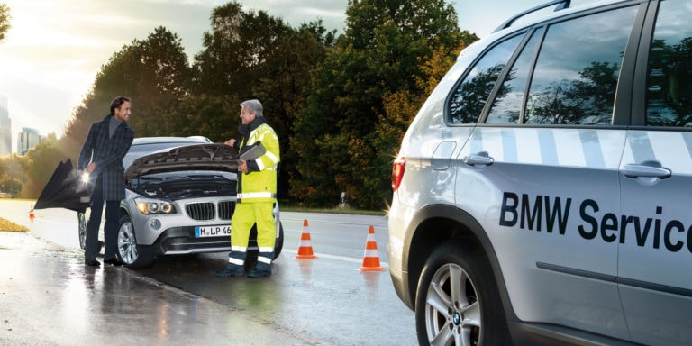 Beispielbild Vögl-Servicemobil. Das Bild zeigt einen liegengebliebenen BMW und das BMW Servicemobil. Der Mitarbeiter kommt dem Fahrer des Pannenfahrzeugs zu Hilfe.