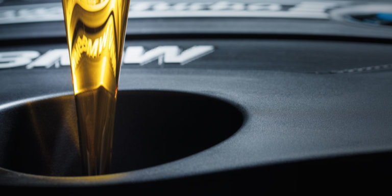 Beispielbild für Öl-Service. Öl wird in BMW Motor gegossen.