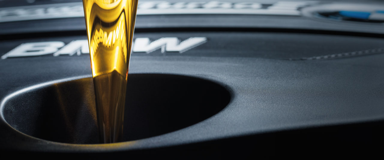 Beispielbild für Öl-Service. Öl wird in BMW Motor gegossen.