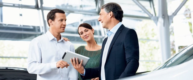 Zwei Männer und eine Frau stehen nebeneinander im Schauraum und unterhalten sich. Beispielbild für Sonderkunden und Sonderkonditionen.